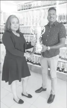  ??  ?? A representa­tive of Trophy Stall’s Berbice branch, Aleena Asgarally, hands over the trophy to competitio­n co-ordinator Roy Jafferally of the Grill Masters softball team.