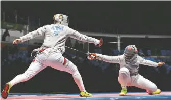  ?? Andrew MEDICHINI/AP ?? LEFT: The fencing jacket and mask worn by Ibtihaj Muhammad, the first American to compete while wearing hijab, during the 2016 Rio Olympics. ABOVE: Muhammad, right, competes with Bogna Jozwiak of Poland in a team saber fencing competitio­n.