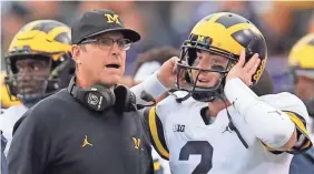  ?? JIM YOUNG/AP ?? Michigan’s Jim Harbaugh, speaking to Shea Patterson, is 32-12 at the school.