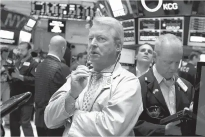  ?? THE ASSOCIATED PRESS ?? New York Stock Exchange trader Dermott Clancy, center, watches stock prices plunge in August amid growing concern over the Chinese economy, the world’s second-largest. China’s sharp slowdown was chosen as the top business story of 2015.