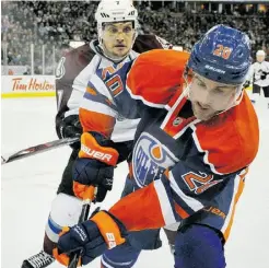  ?? SHAUGHN BUTTS/ EDMONTON JOURNAL FILES ?? Oilers centre Eric Belanger skates into the corner with Colorado Avalanche forward John Mitchell in January at Rexall Place.