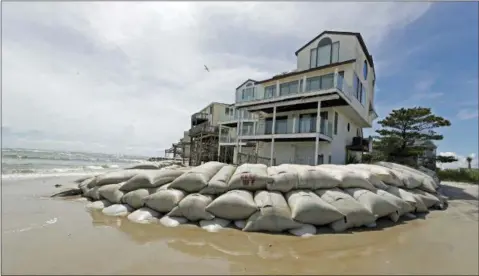  ?? CHUCK BURTON—THE ASSOCIATED PRESS ?? Sand bags surround homes on North Topsail Beach, N.C., Wednesday as Hurricane Florence threatens the coast.