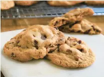  ?? GRETCHEN MCKAY/PITTSBURGH POST-GAZETTE ?? Butterscot­ch pudding mix is the secret weapon in these ooey-gooey cookies studded with chocolate chips and toasted pecans.