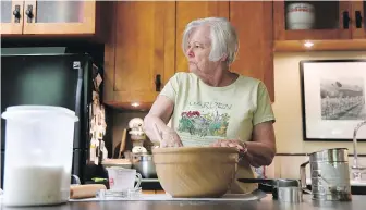  ?? ANNIE RICE, THE ASSOCIATED PRESS ?? Anne Hunt, diagnosed with Alzheimer’s in 2016, looks to her husband, Bruce, to be reminded if she already added sugar to her dough. Hunt, who once ran a cooking school, now has to separate the ingredient­s and mixing to two different sections of the...