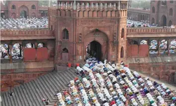  ?? Right) ?? Believers offer prayers during Eid al Fitr at the Jama Masjid mosque in New Delhi on Monday. (