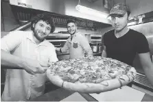  ?? DAN JANISSE ?? Nick Wilson, left, Marco Ieropoli and Brock Warren of Sam’s Pizzeria show off a pie last year after winning the Windsor Pizza Fest.