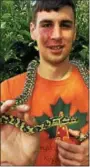  ?? TANIA BARRICKO — DAILY FREEMAN ?? Evan Ducker, a seasonal employee at the Forsyth Nature Center, holds up Voodoo, a 7-year-old carpet python he donated to the Forsyth Nature Center in September of 2011.