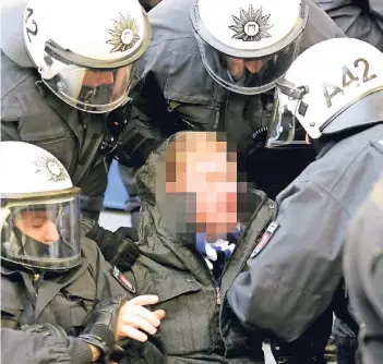  ?? FOTO: REUTERS ?? Bei Ausschreit­ungen nach dem Hamburger 1:2 gegen Hertha BSC ergreifen Polizisten einen Fan des HSV.