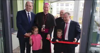  ??  ?? Pupils Jake Purcell and Aoife Dreelan cutting the ribbon of the Catherine McAuley Junior School with Paul Kehoe TD, Bishop Denis Brennan, Mgr Joe McGrath and Brendan Howlin TD.