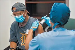  ?? HENRY FORD HEALTH SYSTEM ?? A federal office with expertise in vaccine safety was disbanded in 2019. Above, a volunteer gets a shot as part of a coronaviru­s vaccine trial in August.