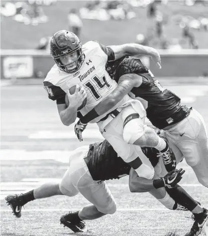  ?? NELL REDMOND/ASSOCIATED PRESS ?? Towson quarterbac­k Tom Flacco is tackled by Wake Forest linebacker­s Demetrius Kemp, left, and Justin Strnad in the first half Saturday. Flacco completed 35 of 51 passes for 345 yards but the Tigers couldn’t contain the Deacons’ specials teams or offense.