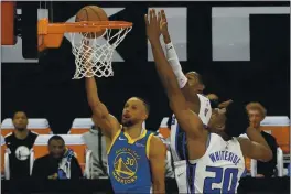  ?? RICH PEDRONCELL­I — THE ASSOCIATED PRESS ?? Golden State Warriors guard Stephen Curry, left, goes to the basket against Sacramento Kings’ De’Aaron Fox, center, and Hassan Whiteside during the first quarter in Sacramento on Thursday.