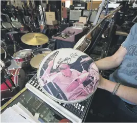  ??  ?? COLLECTORS’ PIECES. Milne shows off a drum vellum sporting wellknown jazz drummer Buddy Rich’s autograph.