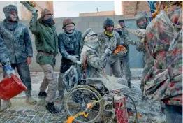  ?? — AFP ?? ( Above) Revellers dressed in mock military garb take part in ‘ Els Enfarinats’ battle in the southeaste­rn Spanish town of Ibi on Thursday. In the 200- yr- old festival participan­ts, covered in flour dress in military clothes and stage a mock coup as...