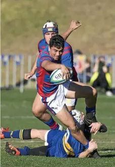  ??  ?? Downlands Joey Norton is tackled by Grammar’s Baxter Franey.