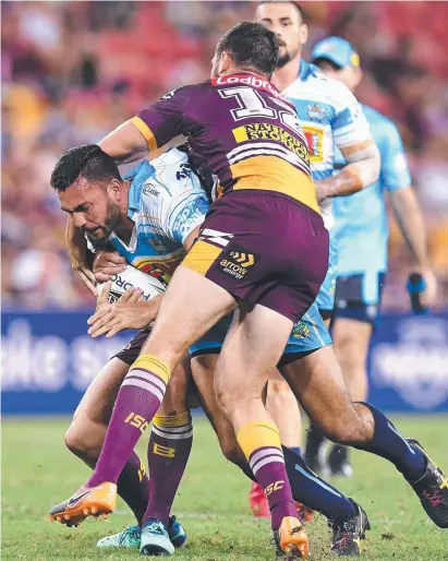  ?? GUTSY EFFORT: Titans player Ryan James takes on the Brisbane defence last night at Suncorp Stadium. ??