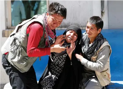 ?? (Mohammad Ismail/Reuters) ?? RELATIVES OF the victims mourn at a hospital after a suicide attack in Kabul yesterday.