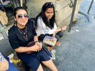  ??  ?? Piazza del Grano Qui vince il fai-da-te: due turiste banchettan­o all’angolo (sotto un’impalcatur­a) con una vaschetta di pasta e insalata