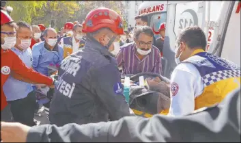  ??  ?? Medics and rescue personnel carry into an ambulance an injured person from the debris of a collapsed building Saturday in Izmir, Turkey.