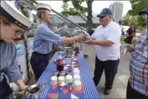  ??  ?? HMCS Haida interprete­r Sarah Simpson serves a tot of rum to Kootenay veteran Wayne Robinson, who served on the ship 1961-62.