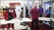  ?? AJC FILE ?? Students walk through security at Maynard Jackson High School in Atlanta. Atlanta, Dekalb and Henry school districts have partnered with Evolv Technology, using their weapons detection devices at middle and high schools.