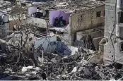  ?? FATIMA SHBAIR / ASSOCIATED PRESS ?? Palestinia­ns survey the destructio­n after an Israeli strike on residentia­l buildings and a mosque in Rafah on Thursday.