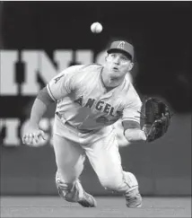  ?? Elaine Thompson Associated Press ?? ANGELS CENTER FIELDER Mike Trout dives toward a f ly ball from Seattle’s Ben Gamel before making the catch.