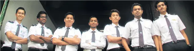  ?? PHOTO: HAMISH MACLEAN ?? Historic flight . . . Old school charm is set to be augmented by new school education as New Zealand Airline Academy student pilots (from left) Anthony Green, Samuel Michael, Muhammad Fakhri, Saravanamo­orthy Yuvarajan, Sonam Jimmy Tshering, Harjit Singh and Rishikumar Jayakumar begin training on a flight simulator installed in historic Harbour St this week.