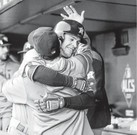  ?? Karen Warren / Staff photograph­er ?? Outfielder Josh Reddick hugs Garrett Stubbs in the dugout after giving the Astros a 2-0 lead with a solo home run in the second.