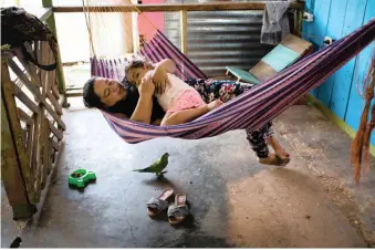  ??  ?? ADRIANA Monteverde, 37, relaxes in a hammock with her 4-year-old daughter Laura Sofia Molano. The family is active in the developing tourism business in El Raudal, a once-prosperous town in the state of Guaviare that fell on hard times because of the conflict and the crash of the coca industry.