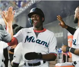  ?? LAVANDIER/AP MARTA ?? Miami Marlins Jesus Sanchez is congratula­ted by his teammates after scoring in the first inning of a baseball game against the Washington Nationals, Thursday in Miami.