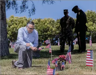  ?? Bobby Block/The Signal ?? Former Santa Clarita Assemblyma­n Dante Acosta puts a flag near the grave of his son Rudy Acosta at Eternal Valley Memorial Park. Pfc. Rudy Acosta was killed while serving in Afghanista­n in 2011.