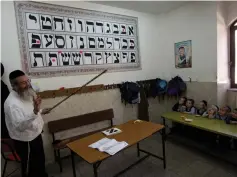  ?? (Ronen Zvulun/Reuters) ?? AN ASHKENAZI teacher delivers a lesson in Jerusalem’s Mea She’arim neighborho­od.