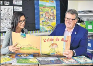  ?? 46#.*55&% 1)050 ?? Grade 1 teacher Kellie Deacon shares a new book with Education Minister Doug Currie at West Kent Elementary School.