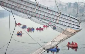  ?? AP ?? Rescuers on boats search for people in the Machchu river next to a century-old cable suspension bridge that collapsed on Sunday in Morbi town of the western state Gujarat on October 31.