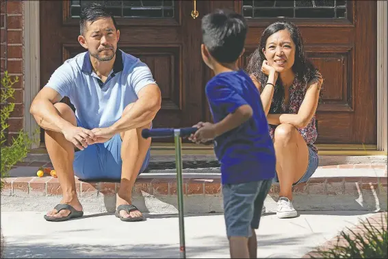  ?? (AP/David J. Phillip) ?? Vicky Li Yip (right) and husband Patrick watch their son Jesse, 5, play outside their home in Houston.