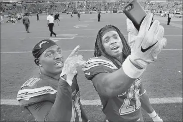  ?? John Cordes Associated Press ?? DESMOND KING, left, has a selfie taken with Melvin Gordon after the Chargers beat the Browns on Sunday.