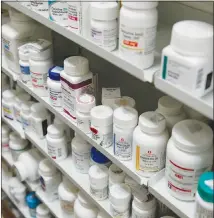  ?? NICOLE CRAINE / THE NEW YORK TIMES ?? Medication­s line the shelves behind the counter at a pharmacy in New York. States are moving to block “gag clauses” that prohibit pharmacist­s from telling customers that they could save money by paying cash for prescripti­on drugs rather than using...