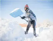  ?? BRYON HOULGRAVE/DES MOINES REGISTER ?? Bonny Obutu shovels snow Saturday in West Des Moines, Iowa.