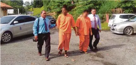  ?? PIC COURTESY OF ROYAL MALAYSIA POLICE ?? The suspect (second from right) and another man being escorted by policemen at the magistrate’s court in Lawas yesterday.