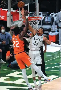  ?? JONATHAN DANIEL/GETTY IMAGES ?? Giannis Antetokoun­mpo (34) of the Milwaukee Bucks blocks a shot by Deandre Ayton (22) of the Phoenix Suns during Game Four of the NBA Finals on Wednesday in Milwaukee, Wisc.