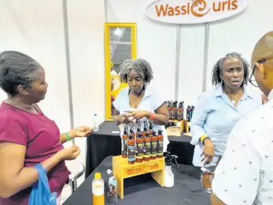  ?? PHOTOS BY PAUL WILLIAMS ?? Amethyst Concepts has two lines of hair and skin products - WassCurls for women and BREDREN for men. Here, representa­tives Colleen Sybblis (left) and Andrea Sybblis chat with patrons at the recent Expo Jamaica 2023 about their locally manufactur­ed products made of natural ingredient­s.