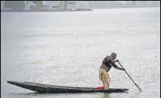  ?? WASEEM ANDRABI/HT ?? A man rows his boat at Dal Lake during rain in Srinagar on Thursday.