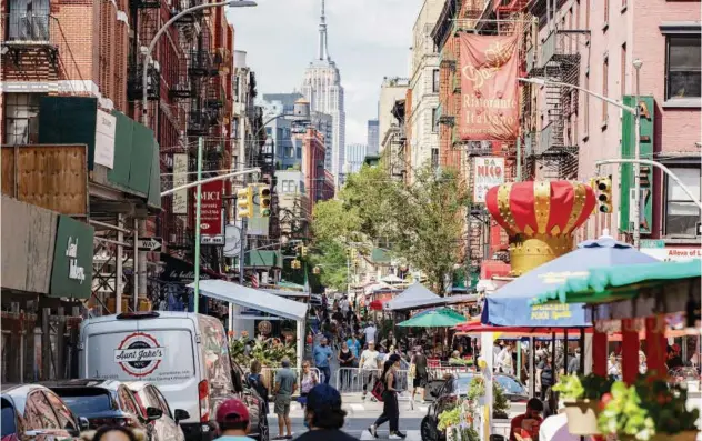  ?? File/reuters ?? ↑
People walk down a street lined with outdoor seating for restaurant­s in the Little Italy neighborho­od of Manhattan, in New York City.