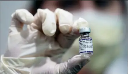  ?? LYNNE SLADKY—ASSOCIATED PRESS ?? A healthcare worker holds a vial of the Pfizer Covid-19vaccine at Jackson Memorial Hospital in Miami, in this Tuesday, Oct. 5, 2021, file photo. Pfizer asked the U.S. government Thursday, Oct. 7, 2021, to allow use of its Covid-19vaccine in children ages 5to 11— and if regulators agree, shots could begin within a matter of weeks.