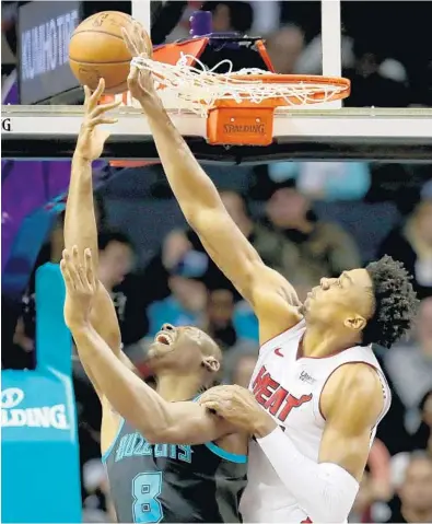  ?? STREETER LECKA/GETTY ?? Hassan Whiteside of the Heat puts his hand through the net as he tries to stop Bismack Biyombo of the Hornets on Wednesday.
