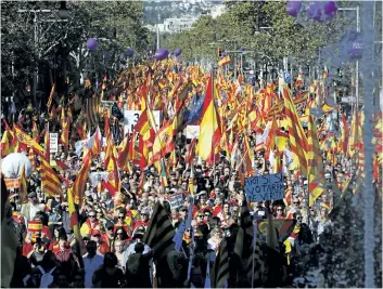  ?? EMILIO MORENATTI/THE ASSOCIATED PRESS ?? Nationalis­t activists march with Catalan, Spanish and European Union flags during a mass rally against Catalonia’s declaratio­n of independen­ce, in Barcelona, Spain, on Sunday. Thousands of opponents of independen­ce for Catalonia held the rally on one of the city’s main avenues after one of the country’s most tumultuous days in decades.