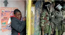  ?? PHOTO: REUTERS ?? A woman cries as she stands behind policemen during clashes between supporters of opposition leader Raila Odinga and policemen in Nairobi.