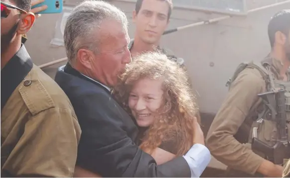  ?? Picture: AP ?? Ahed Tamimi is hugged by her father Bassem as she is released from an Israeli prison after serving an eight-month sentence.