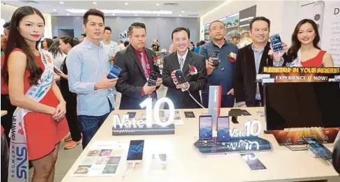  ?? FOTO: ?? BADROL (tiga dari kiri), Ko dan Kelvin (enam dari kiri) melihat barisan model telefon jenama Huawei selepas melancarka­n Huawei Experience Store di pusat beli-belah Kinta City.